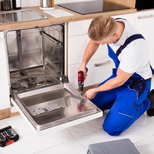 man fixing dishwasher-repair appliances before holidays